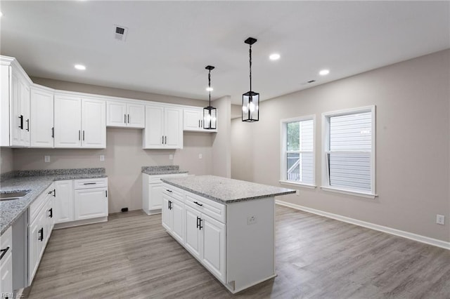 503 Middlesex St, Norfolk, VA 23523 - kitchen featuring a center island, light wood finished floors, recessed lighting, light stone countertops, and white cabinetry