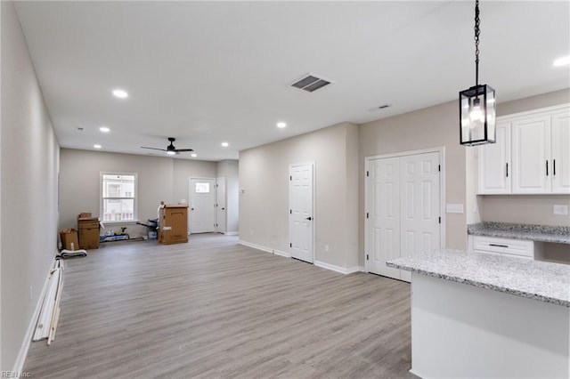 503 Middlesex St, Norfolk, VA 23523 - kitchen featuring light wood-type flooring, white cabinets, baseboards, a ceiling fan, and light stone countertops