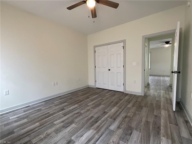 103 Lawrence Dr, Elizabeth City, NC 27909 - unfurnished bedroom featuring dark wood-style flooring, baseboards, a closet, and a ceiling fan