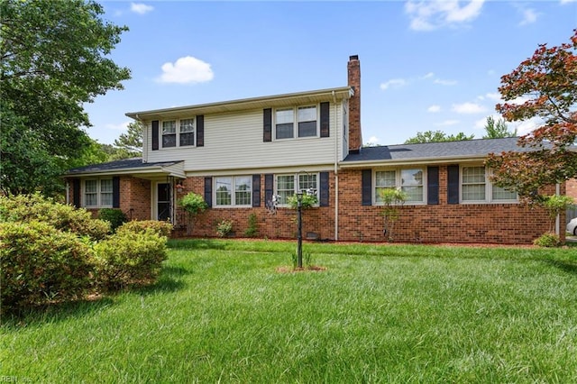 view of front of home featuring a chimney, a front lawn, and brick siding
