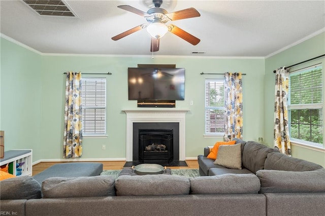 5049 Kelso St, Suffolk, VA 23435 - living room with ornamental molding, wood finished floors, a fireplace with flush hearth, a ceiling fan, and baseboards