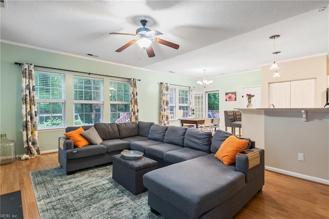 5049 Kelso St, Suffolk, VA 23435 - living room featuring a chandelier, healthy amount of natural light, wood finished floors, ceiling fan, and ornamental molding