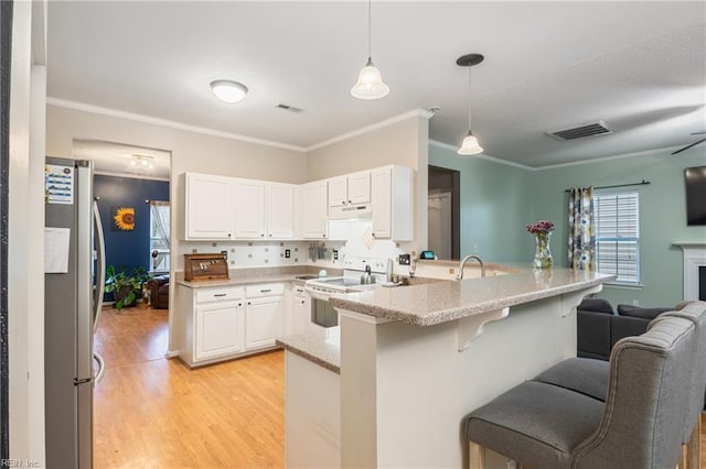 5049 Kelso St, Suffolk, VA 23435 - kitchen with electric range, freestanding refrigerator, a peninsula, a breakfast bar area, and light wood-style floors