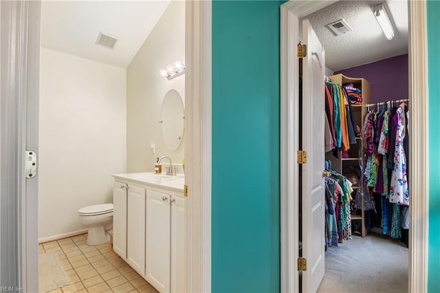 5049 Kelso St, Suffolk, VA 23435 - bathroom with vanity, a spacious closet, toilet, and tile patterned flooring