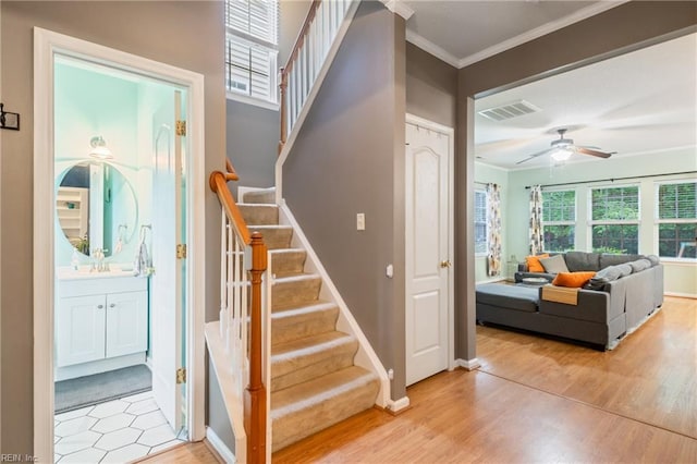 5049 Kelso St, Suffolk, VA 23435 - stairway with crown molding, wood finished floors, ceiling fan, and baseboards