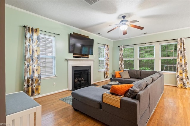5049 Kelso St, Suffolk, VA 23435 - living area featuring crown molding, wood finished floors, a ceiling fan, a fireplace with flush hearth, and baseboards