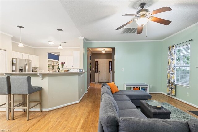 5049 Kelso St, Suffolk, VA 23435 - living area featuring light wood-style floors, ornamental molding, a ceiling fan, and baseboards