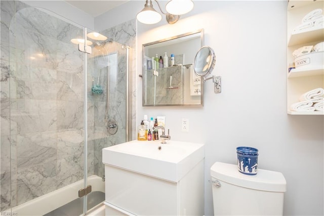 bathroom featuring toilet, vanity, and shower / bath combination with glass door