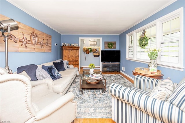 living room with wood finished floors, crown molding, and baseboards
