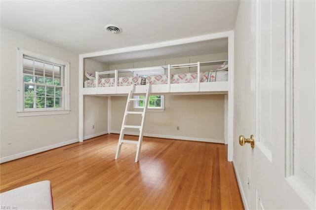 122 Archer Rd, Newport News, VA 23606 - unfurnished bedroom featuring multiple windows, wood finished floors, and baseboards