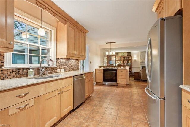 122 Archer Rd, Newport News, VA 23606 - kitchen featuring appliances with stainless steel finishes, a sink, light brown cabinetry, decorative backsplash, and pendant lighting