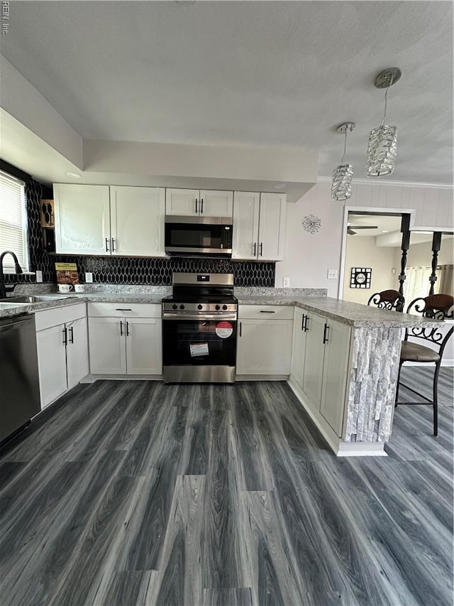 2800 Candlewood Cir, Chesapeake, VA 23324 - kitchen with appliances with stainless steel finishes, a sink, a peninsula, white cabinetry, and tasteful backsplash