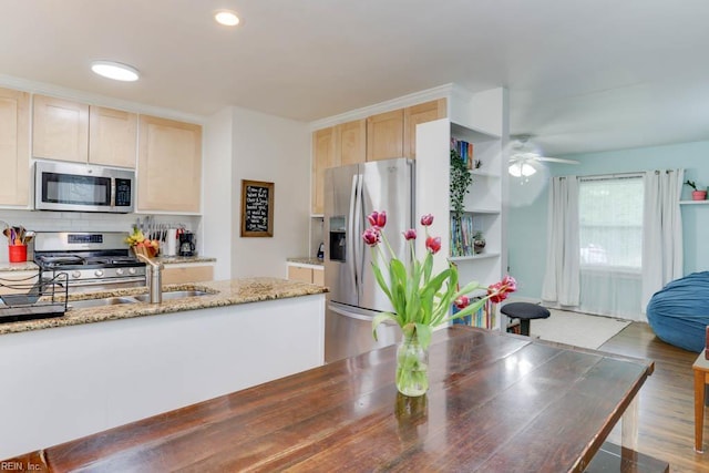 8140 Kenwood Dr, Norfolk, VA 23518 - kitchen featuring appliances with stainless steel finishes, light brown cabinetry, a ceiling fan, tasteful backsplash, and light stone counters