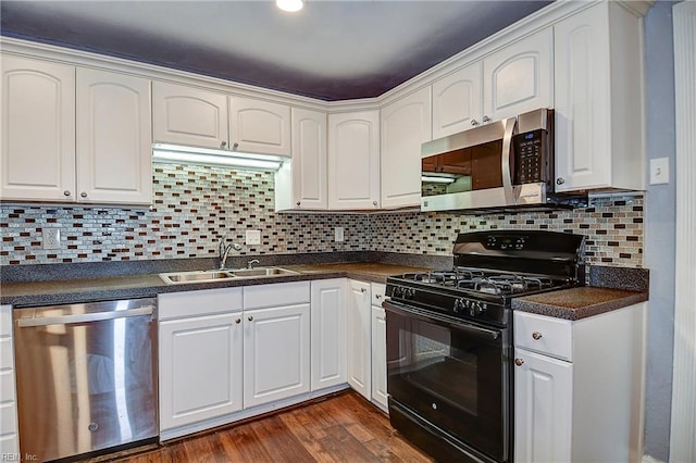 3582 Tennessee Ave, Norfolk, VA 23502 - kitchen featuring appliances with stainless steel finishes, a sink, dark countertops, dark wood-style floors, and white cabinetry