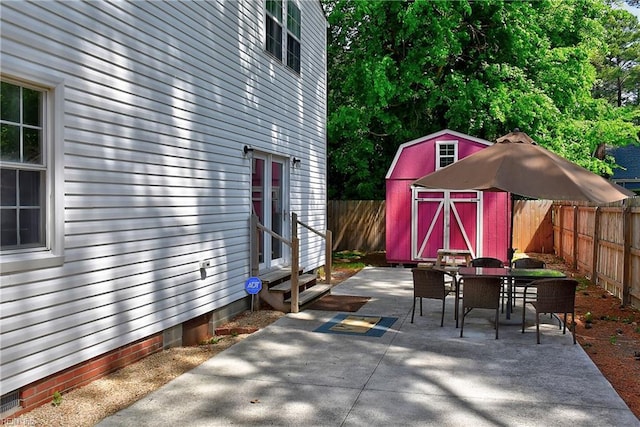 3582 Tennessee Ave, Norfolk, VA 23502 - view of patio / terrace with entry steps, outdoor dining area, a fenced backyard, a storage shed, and an outdoor structure