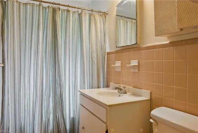 116 Sycamore Rd, Franklin, VA 23851 - full bathroom featuring toilet, vanity, tile walls, a shower with curtain, and wainscoting