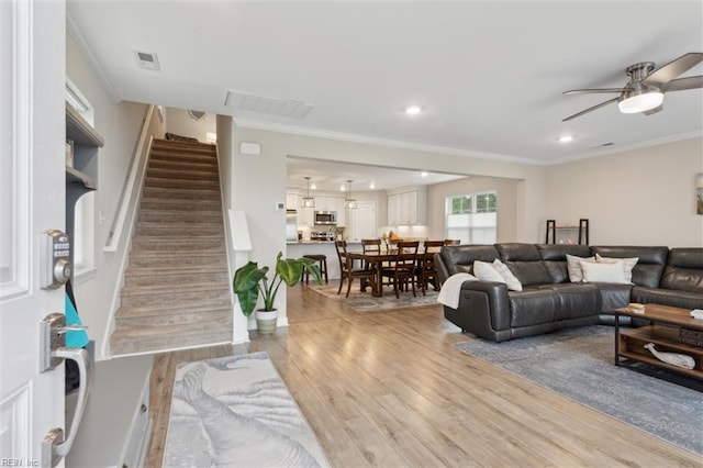 1430 Poquoson Ave, Poquoson, VA 23662 - living area with stairway, light wood finished floors, a ceiling fan, crown molding, and recessed lighting