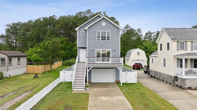 1430 Poquoson Ave, Poquoson, VA 23662 - view of front of property featuring stairway, concrete driveway, a gate, an attached garage, and view of scattered trees