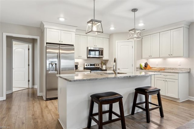 1430 Poquoson Ave, Poquoson, VA 23662 - kitchen featuring appliances with stainless steel finishes, white cabinets, recessed lighting, light stone counters, and light wood-style floors