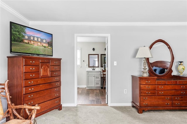 bedroom featuring carpet flooring, crown molding, baseboards, and ensuite bath
