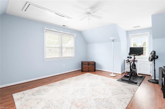 workout room with attic access, lofted ceiling, ceiling fan, and wood finished floors