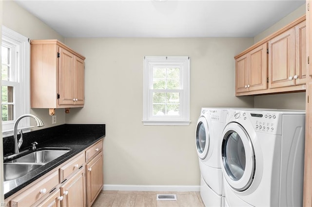 laundry area featuring washer and clothes dryer, cabinet space, baseboards, and light tile patterned flooring