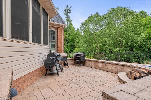 view of patio featuring fence and a grill