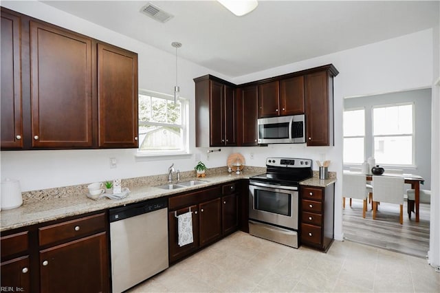 1060 Fairgrounds Ln, Suffolk, VA 23434 - kitchen with stainless steel appliances, a sink, decorative light fixtures, light stone countertops, and dark brown cabinets
