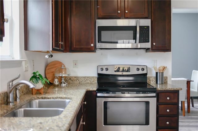 1060 Fairgrounds Ln, Suffolk, VA 23434 - kitchen featuring stainless steel appliances, a sink, dark brown cabinetry, light stone counters, and wood finished floors
