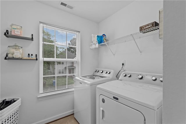 washroom featuring washing machine and dryer and baseboards