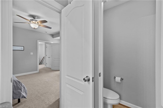 bathroom featuring a ceiling fan, baseboards, and toilet