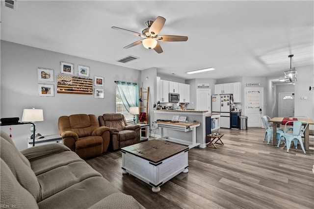 living area featuring a ceiling fan and wood finished floors