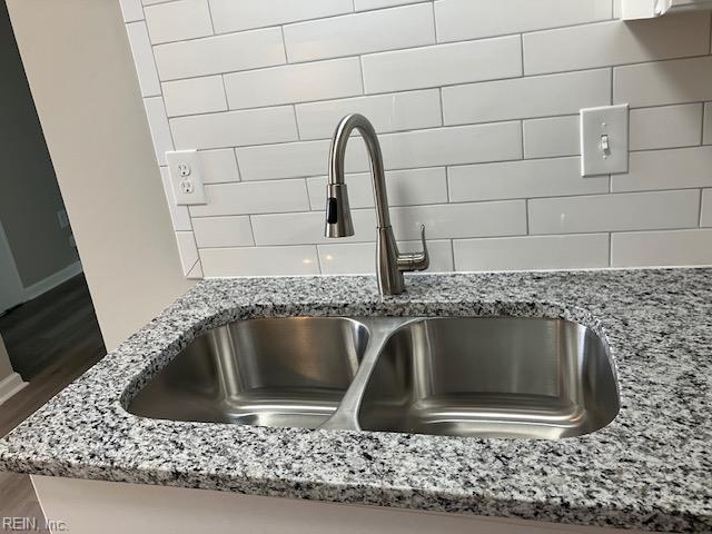 12765 Woodside Ln, Newport News, VA 23602 - kitchen view of a sink, light stone counters, baseboards, and tasteful backsplash