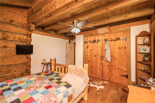 bedroom with beamed ceiling, wood ceiling, and wood finished floors