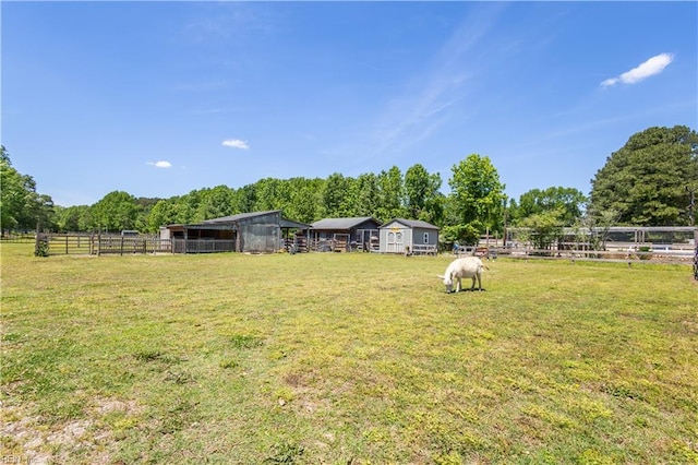view of yard with an exterior structure, an outdoor structure, and a rural view