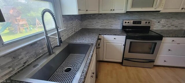 49 Church St, Poquoson, VA 23662 - kitchen with stainless steel range with electric cooktop, white microwave, a sink, and white cabinets