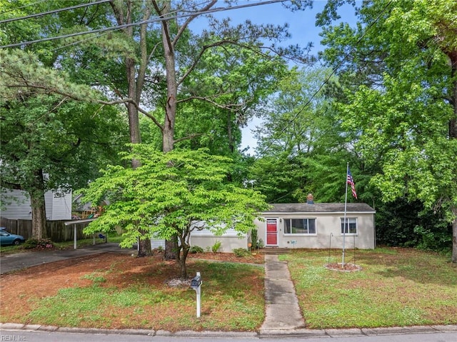 view of front facade with stucco siding, a carport, and asphalt driveway