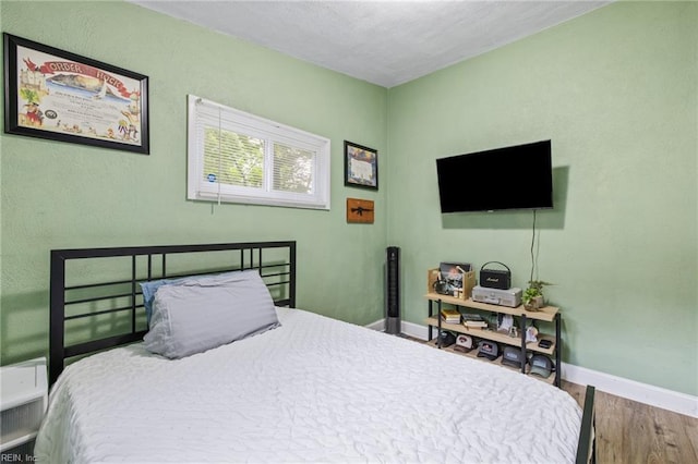 bedroom featuring wood finished floors and baseboards