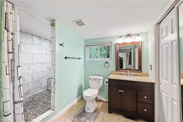 full bathroom featuring tiled shower, vanity, toilet, baseboards, and tile patterned flooring