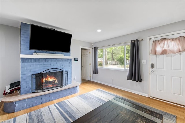 unfurnished living room featuring wood finished floors, a fireplace, baseboards, and recessed lighting