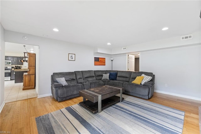 living area with light wood finished floors, recessed lighting, and baseboards