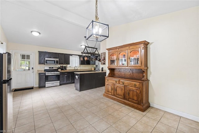 kitchen with stainless steel appliances, a chandelier, vaulted ceiling, light tile patterned floors, and a sink
