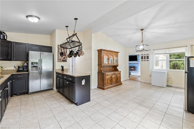 kitchen featuring stainless steel fridge, freestanding refrigerator, light tile patterned floors, and pendant lighting