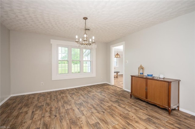 13542 Brink Rd, Emporia, VA 23847 - unfurnished dining area with a chandelier, wood finished floors, and baseboards