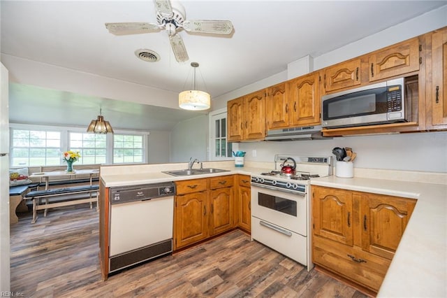 13542 Brink Rd, Emporia, VA 23847 - kitchen featuring white appliances, a sink, under cabinet range hood, a peninsula, and brown cabinets
