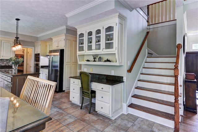 4901 Toddington Cir, Williamsburg, VA 23188 - kitchen with appliances with stainless steel finishes, cream cabinets, a textured ceiling, decorative light fixtures, and a kitchen island