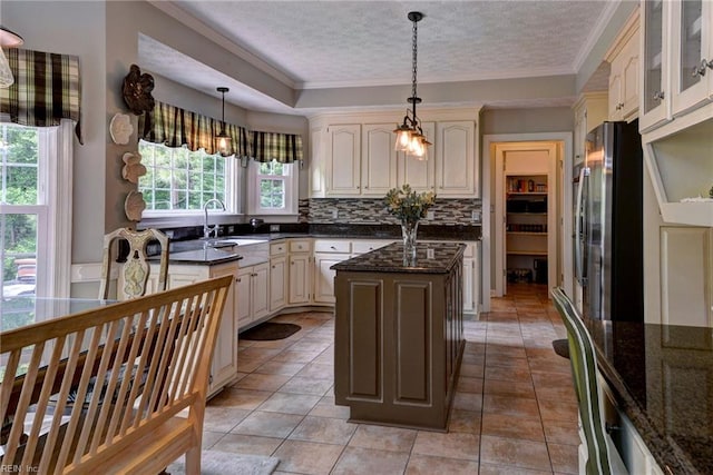 4901 Toddington Cir, Williamsburg, VA 23188 - kitchen featuring freestanding refrigerator, ornamental molding, cream cabinets, tasteful backsplash, and a textured ceiling