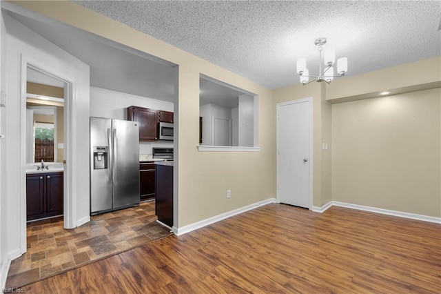 5217 Bardith Cir, Virginia Beach, VA 23455 - unfurnished dining area with a chandelier, a sink, a textured ceiling, and baseboards