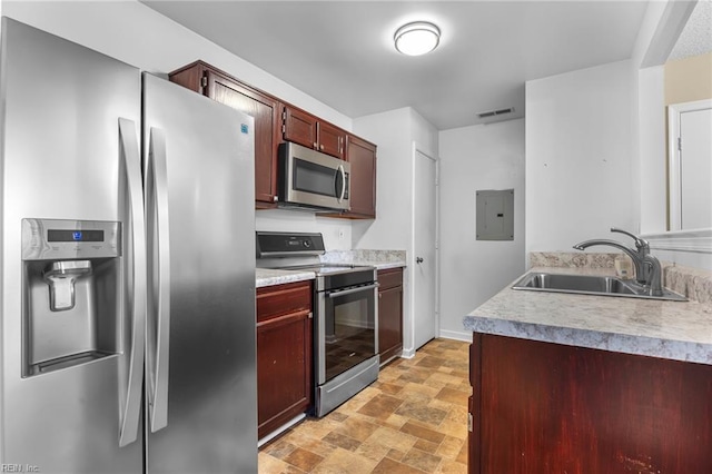 5217 Bardith Cir, Virginia Beach, VA 23455 - kitchen with stainless steel appliances, a sink, stone finish floors, electric panel, and reddish brown cabinets