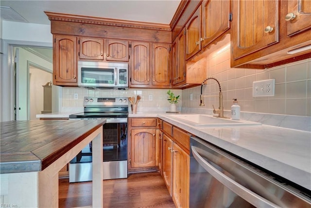 1305 Oak Ridge Dr, Chesapeake, VA 23322 - kitchen with stainless steel appliances, a sink, dark wood-style floors, backsplash, and brown cabinets